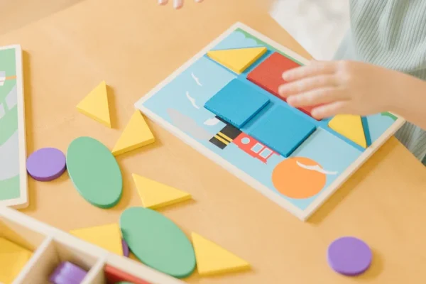Child developing artistic talents through forming patterns with blocks.